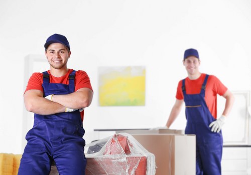 Professional movers carrying boxes through a narrow staircase